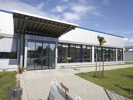 Moderne, silberne Gebäudehalle mit bodentiefen Fenstern