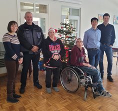 Spendenübergabe unterm Weihnachtsbaum: Friederike Lau (Sozialdienst), Frank Heckl (Leiter der Werkstatt Peine), Helma Meyer und Christian Freyhold (beide Beschäftigte der Werkstatt) mit Ho-Man Lau und Simon Goy (beide Geschäftsführer der Firma Goy und Balke) (v.l.n.r.)