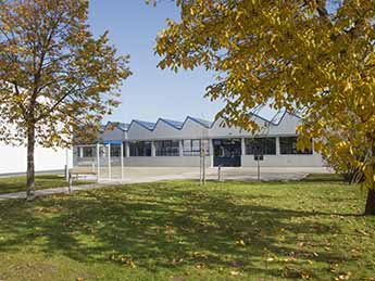 silberne Gebäudehalle mit gezacktem Dach für PV-Anlage. 