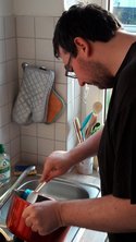 Ein Mann beim Abwaschen in seiner Küche.